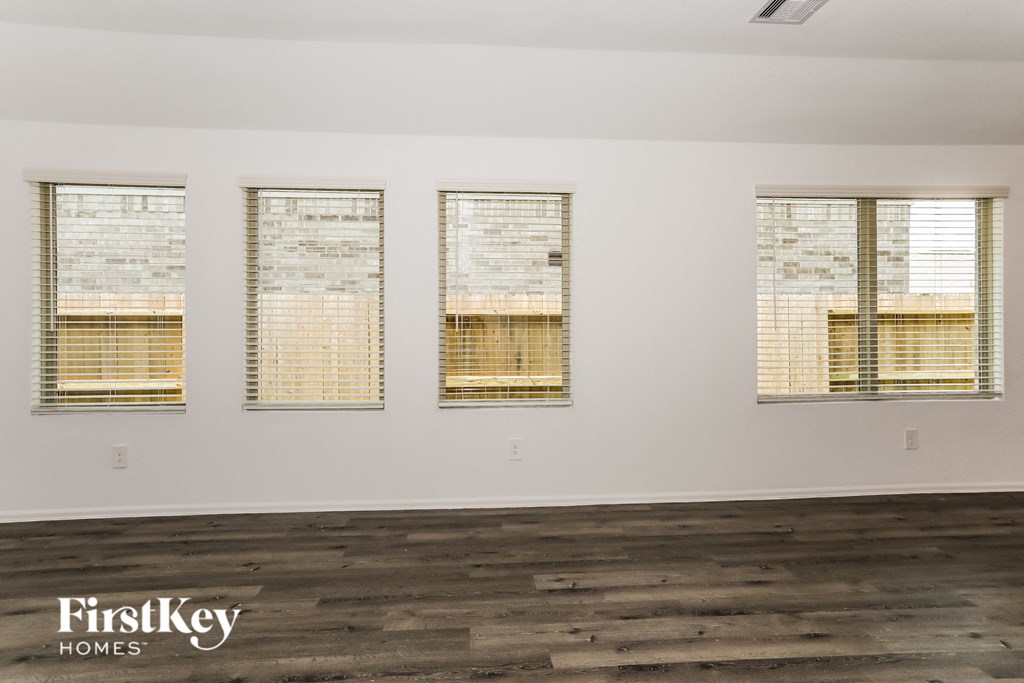 the living room of a house with windows and wood floors