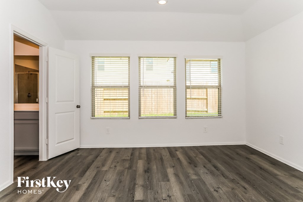 the living room of a home with wood floors and white walls