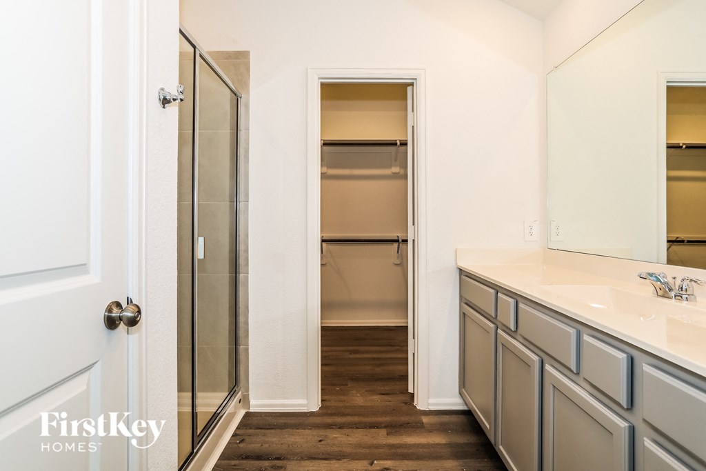 a bathroom with two sinks and a shower and a closet