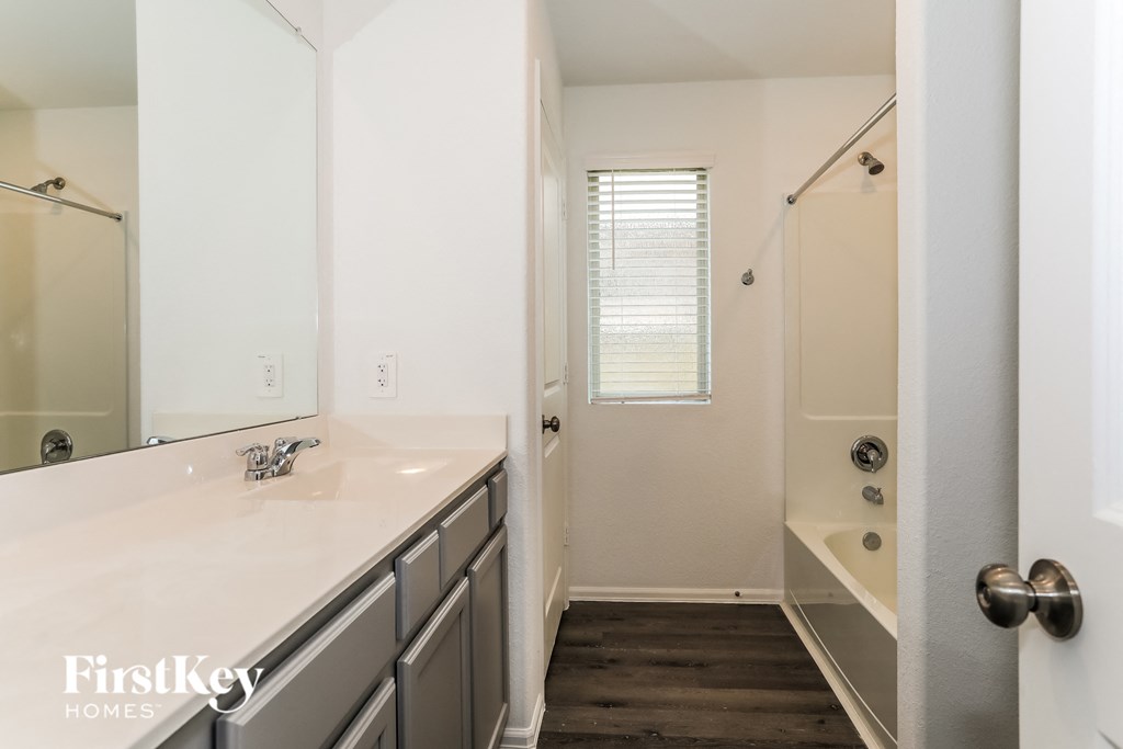 a bathroom with a large mirror and a sink and a shower