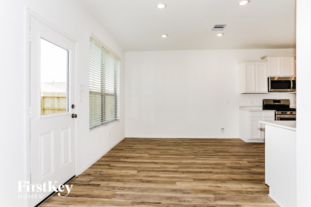 a kitchen and living room with wood floors and white walls