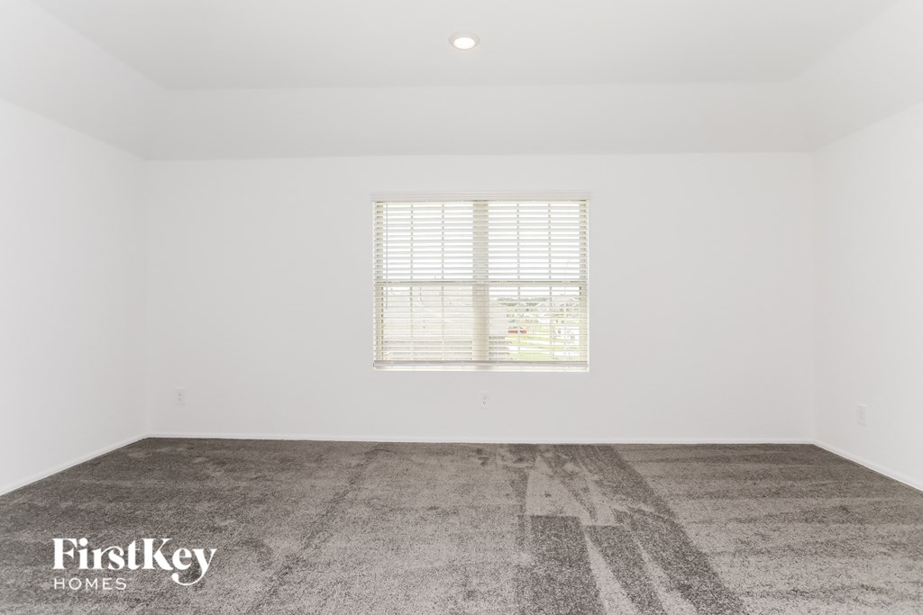 a white room with a window and a cement floor