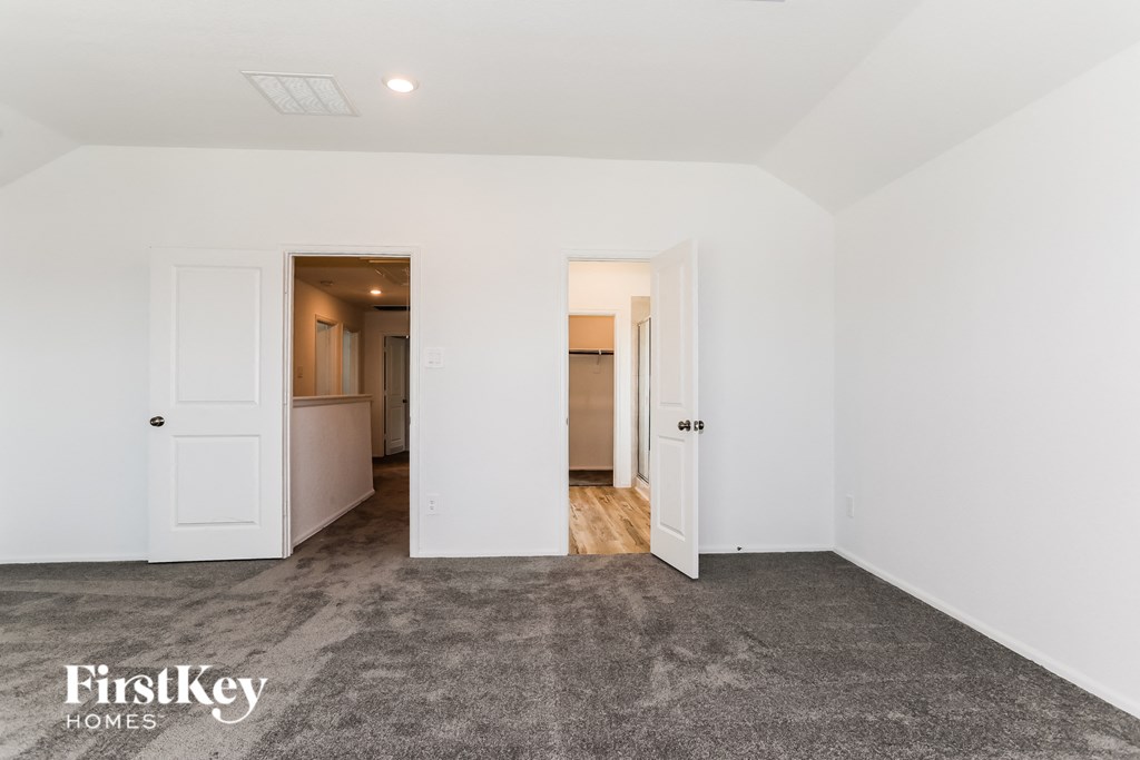a bedroom with white walls and white doors and a carpeted floor
