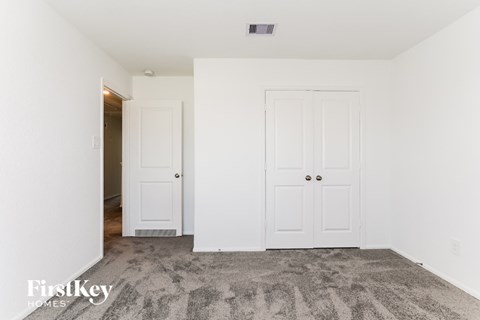 a bedroom with two white doors and a carpeted floor