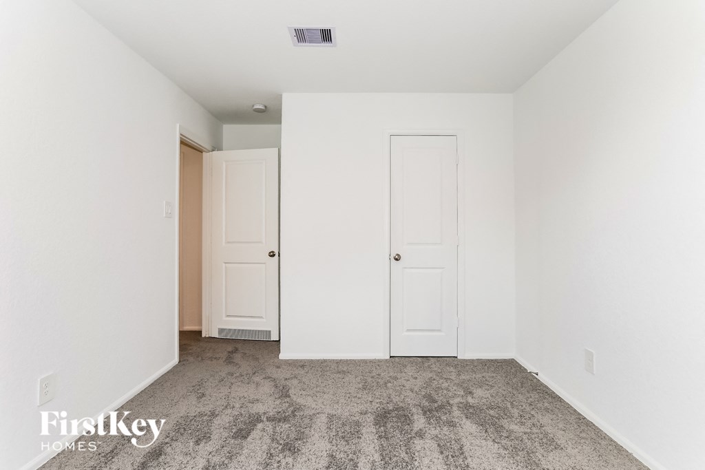 a bedroom with two white doors and a carpeted floor
