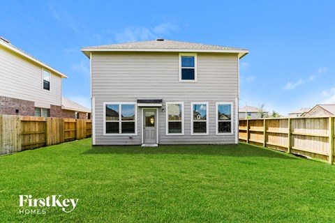 a white house with a yard and a wooden fence
