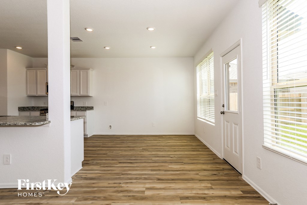 a kitchen and living room with wood floors and white walls