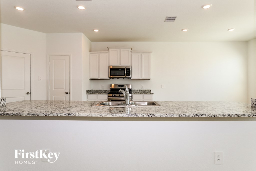 a kitchen with white cabinets and a granite counter top