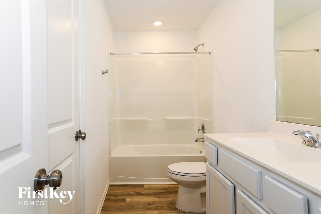 a white bathroom with a shower and toilet and a sink