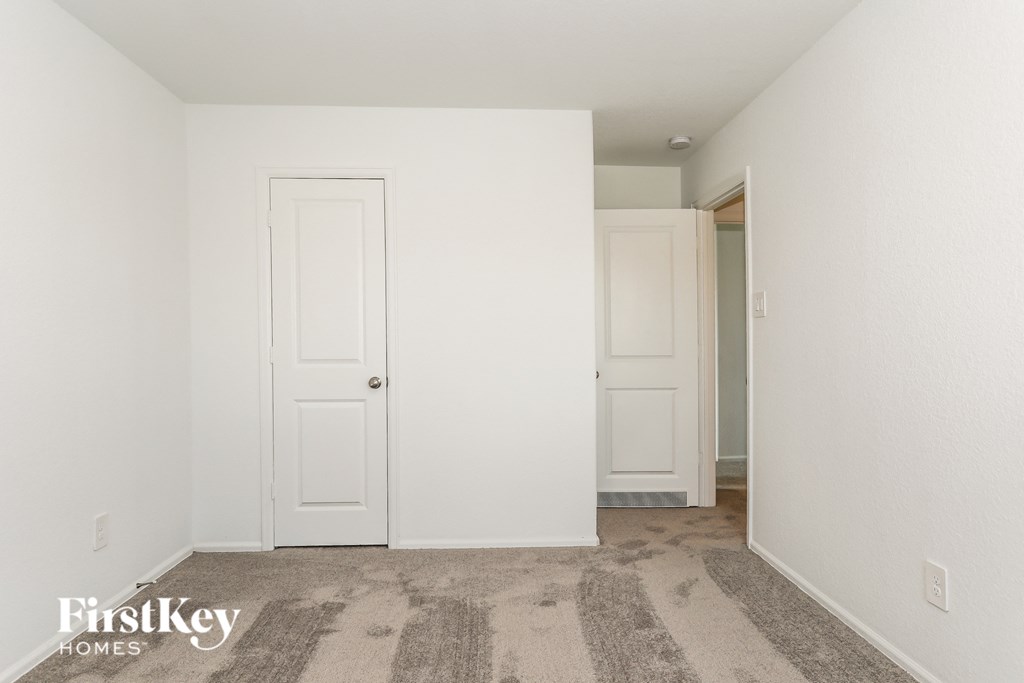 a bedroom with two white doors and a carpeted floor