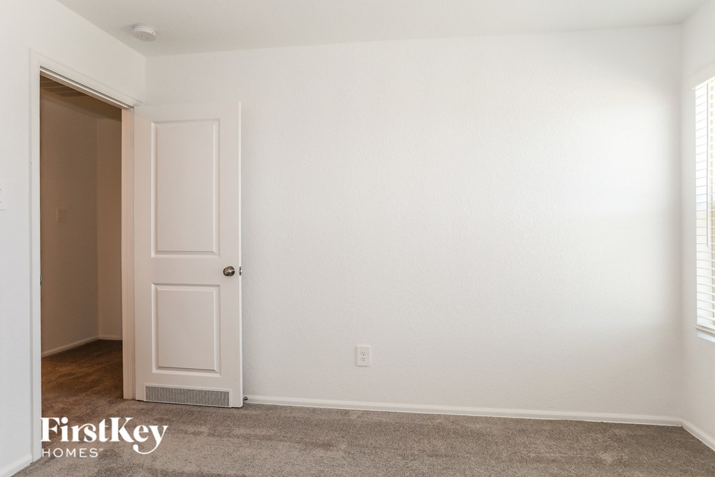a room with a white door and a white wall and a carpet