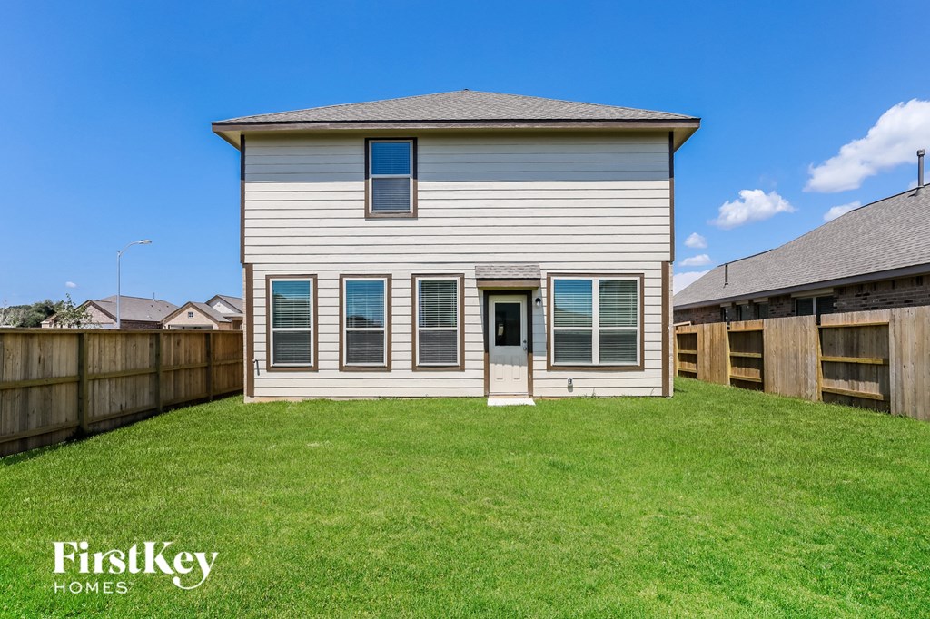 a white house with a yard and a wooden fence