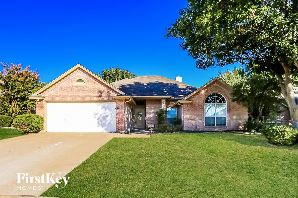 a brick house with a white garage door and a lawn