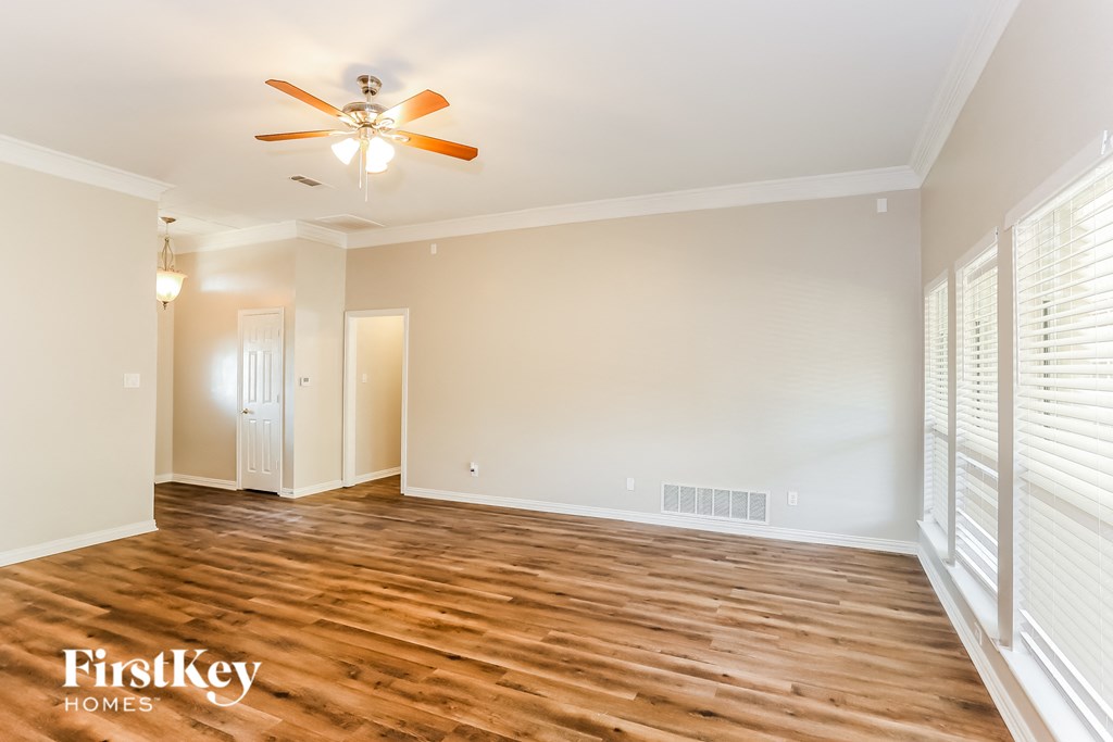 a living room with wood flooring and a ceiling fan