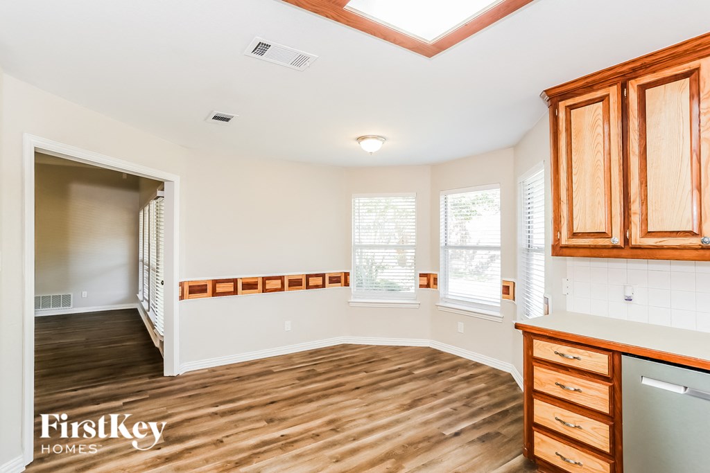 a kitchen and living room with wood flooring and wooden cabinets