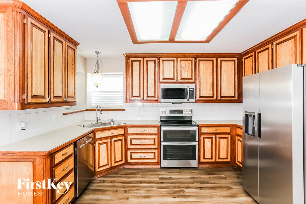 a kitchen with wooden cabinets and stainless steel appliances