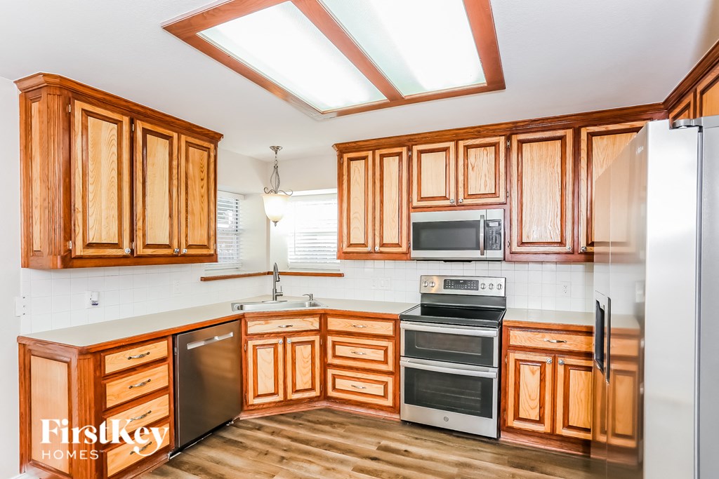a kitchen with wooden cabinets and stainless steel appliances