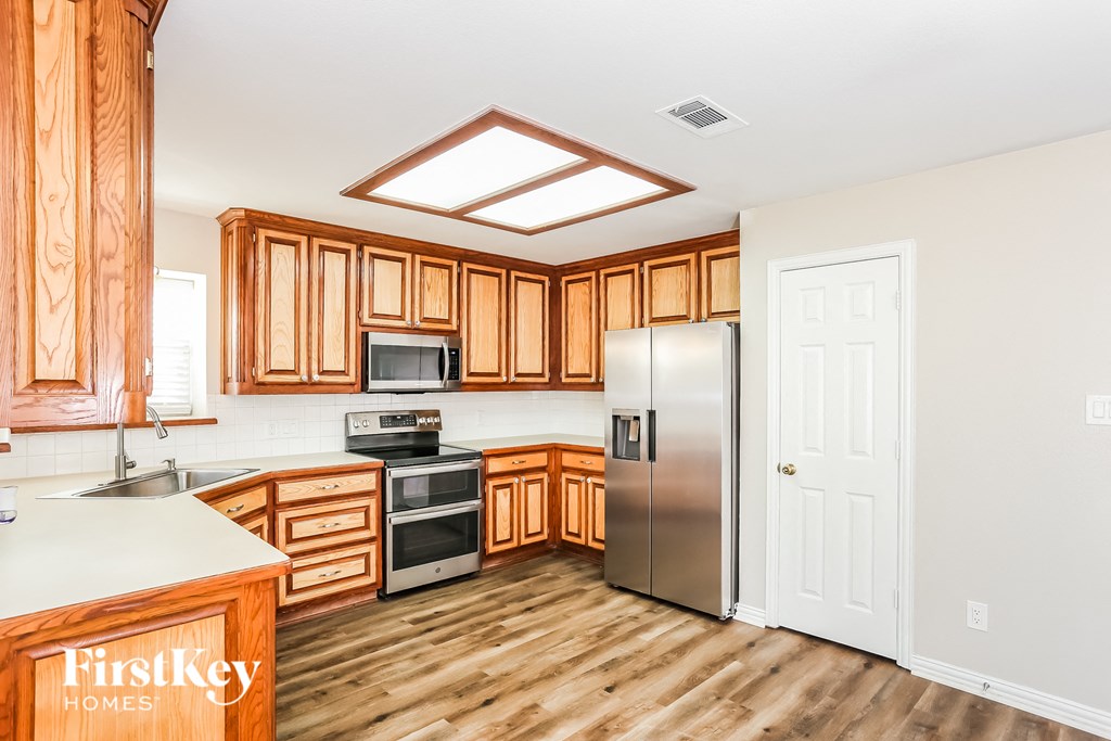a kitchen with wooden cabinets and stainless steel appliances