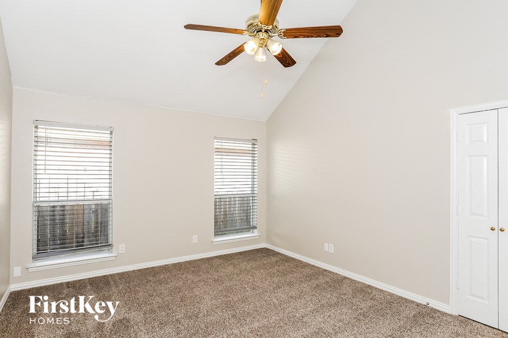 a bedroom with carpet and a ceiling fan