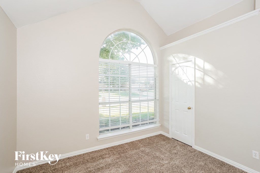 a bedroom with a large arched window and a door