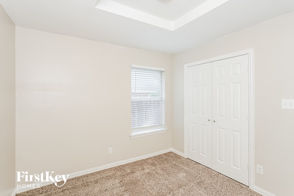 a bedroom with a closet and a door and a window
