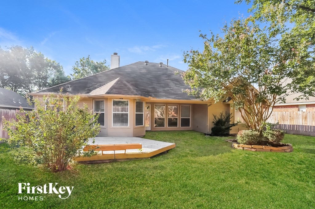 a backyard with a deck and a house