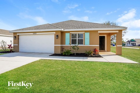 a beige house with a lawn and a garage door