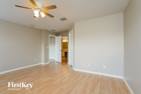 a living room with wood floors and a ceiling fan