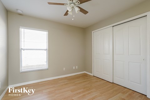 a bedroom with a ceiling fan and a closet