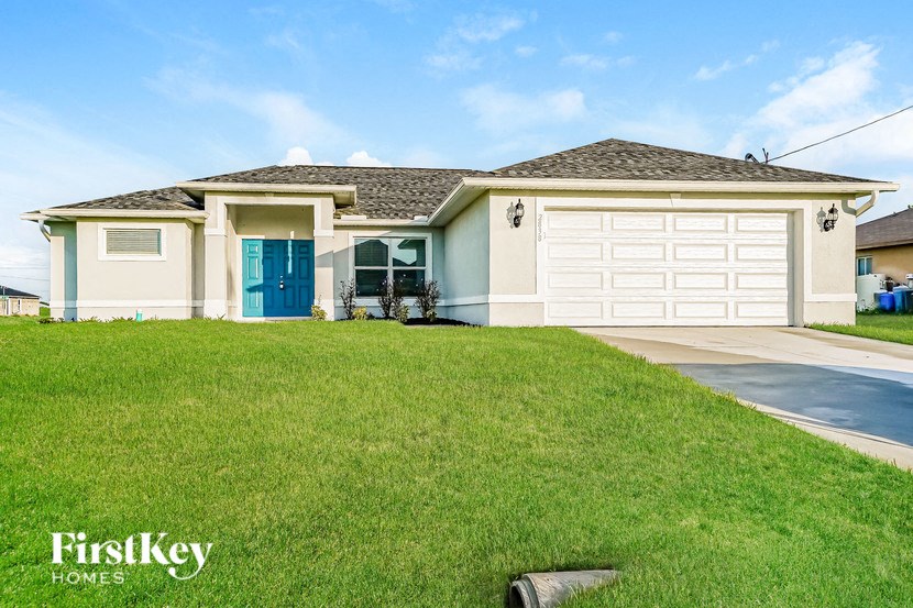 A house with a blue door and a white garage door is for sale by FirstKey Homes.