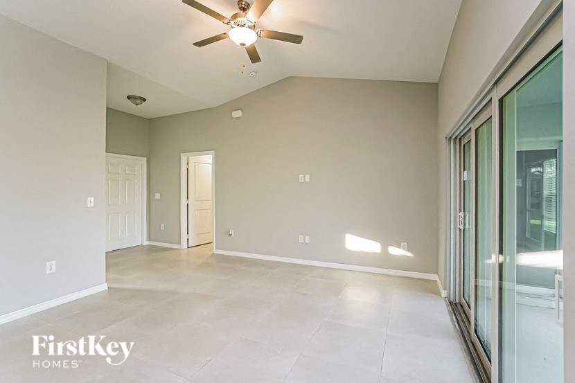 A spacious room with a ceiling fan and sliding glass doors.