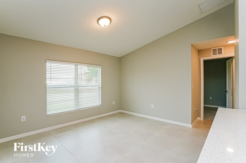 A room with a window and a door leading to another room.