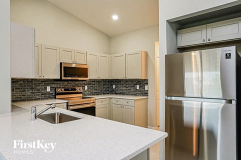 A kitchen with a stainless steel refrigerator and a sink.