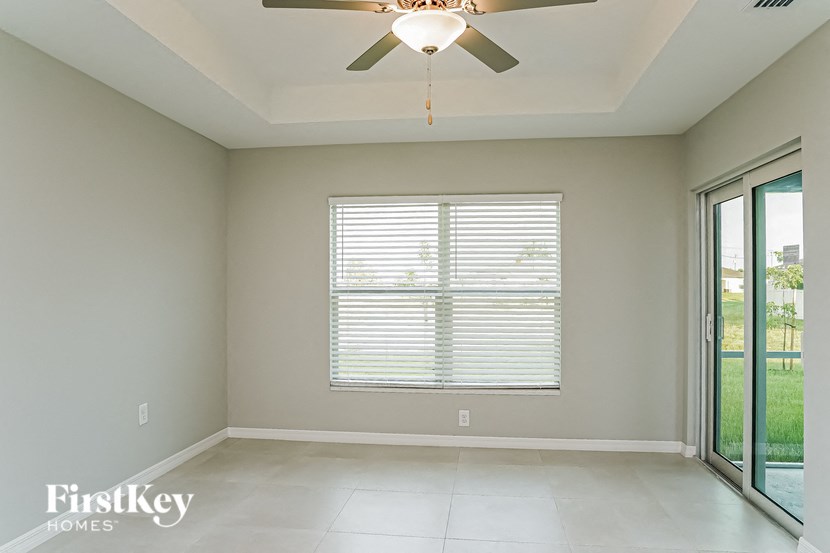 A room with a ceiling fan and a window with blinds.
