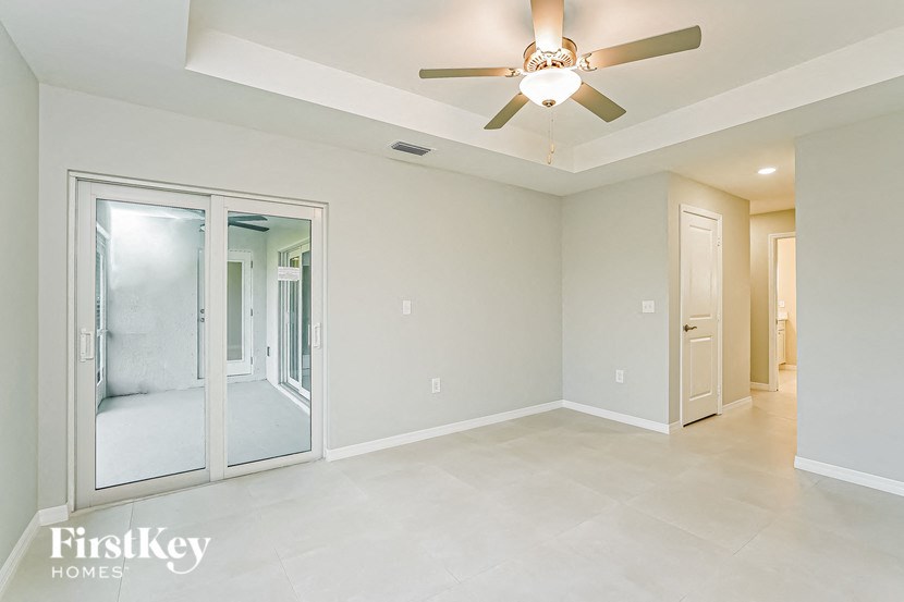 A spacious room with a ceiling fan and sliding glass doors.