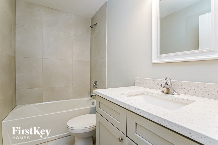 A white toilet sits next to a bathtub in a bathroom.