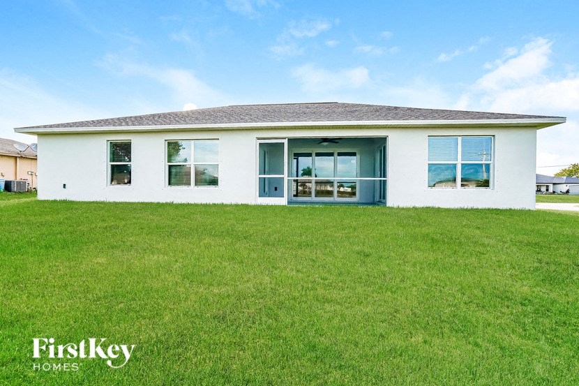 A white house with a grey roof and a blue sky in the background.