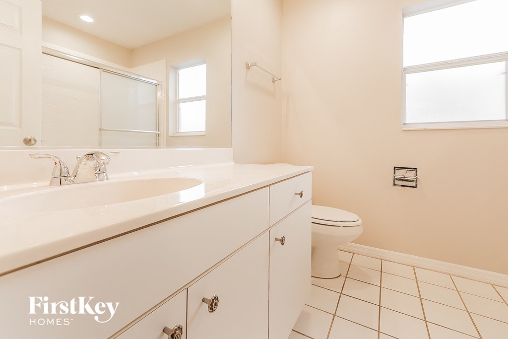 A bathroom with a white sink and a toilet.