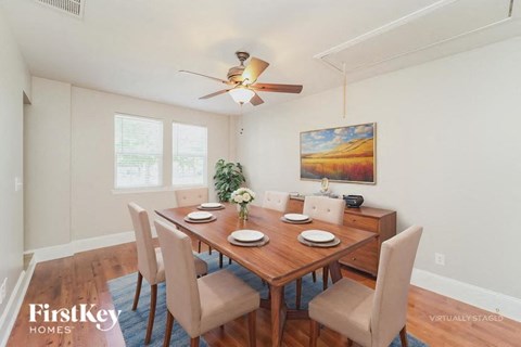A dining room with a wooden table and chairs.