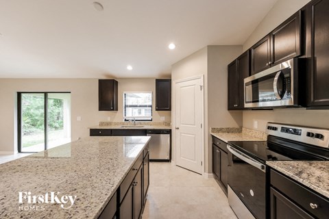 a modern kitchen with granite counter tops and black cabinets