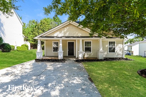 a small white house with a sidewalk in front of it
