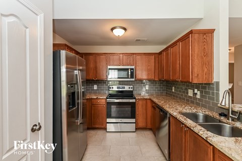 full kitchen with stainless steel appliances and granite counter tops and wood cabinets