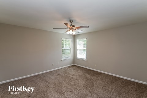 a bedroom with carpet and a ceiling fan