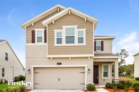 a tan and brown house with a garage door