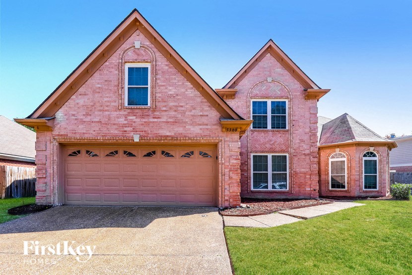 a pink brick house with a pink garage door