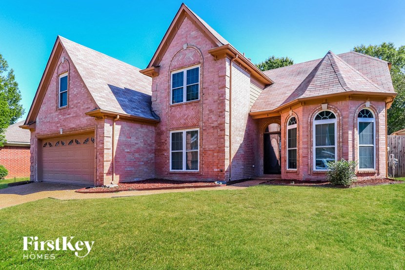 a brick house with a lawn in front of it