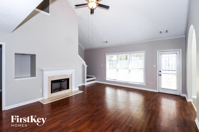 the living room with wood floors and a fireplace