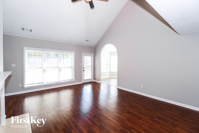 the living room with hard wood floors and a ceiling fan