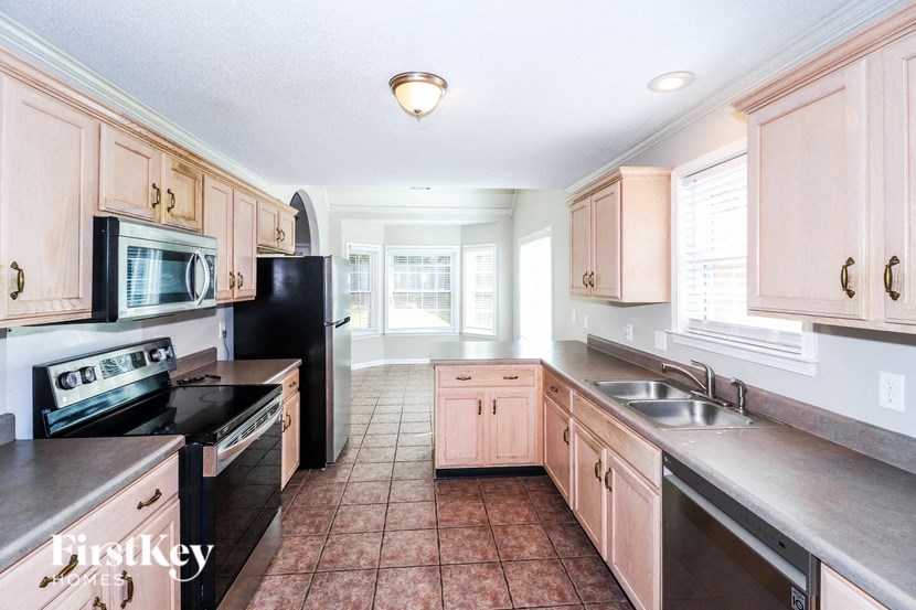 a kitchen with wood cabinets and black appliances and a sink