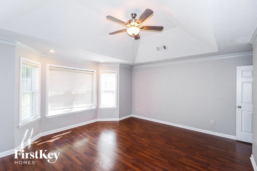 the living room with wood floors and a ceiling fan